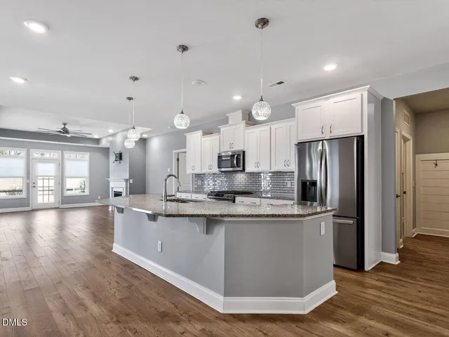 a kitchen with kitchen island a sink stove and refrigerator