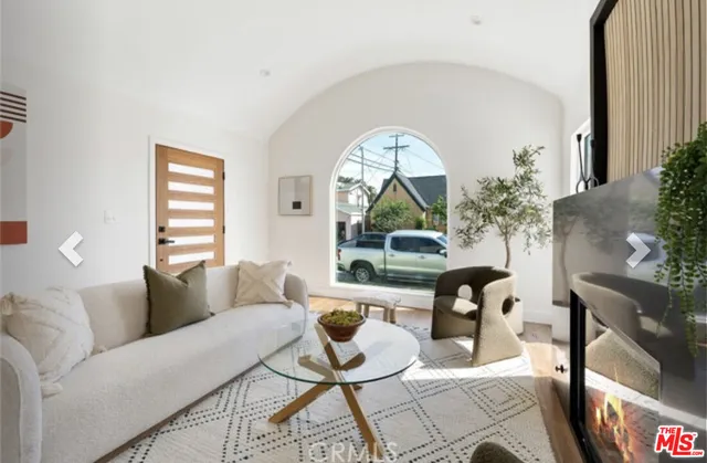 a living room with furniture a window and a potted plant