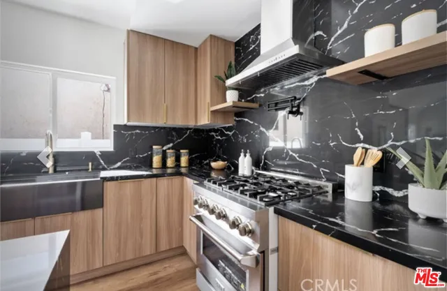a kitchen with granite countertop a sink stove and cabinets