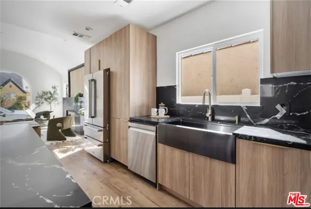 a kitchen with stainless steel appliances granite countertop a sink stove and refrigerator
