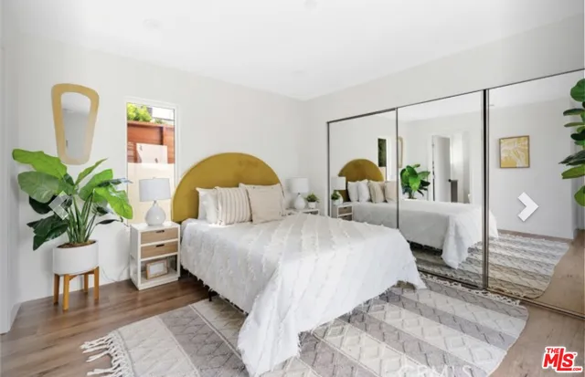a large white bed in a bedroom next to a window
