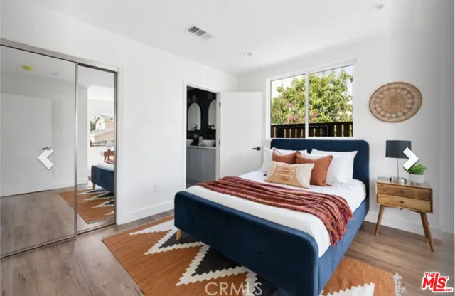 a bedroom with a bed and a painting on the wall