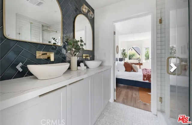 a en suite bathroom with a granite countertop sink and a mirror