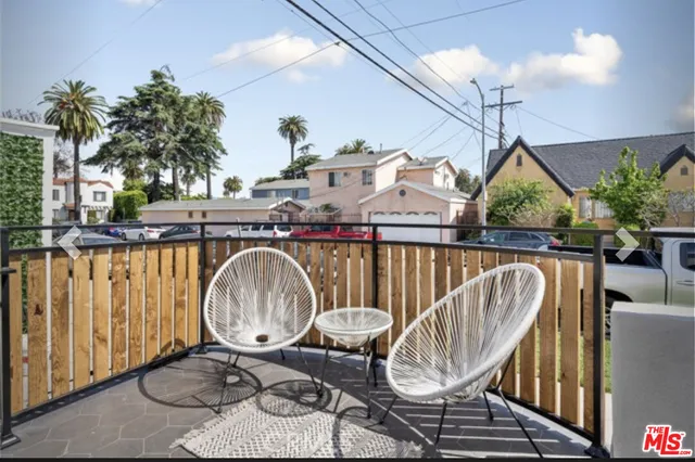 a view of a balcony with wooden furniture