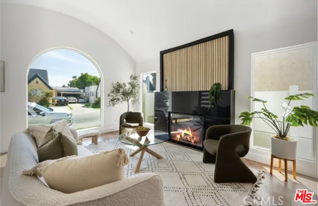 a living room with furniture a flat screen tv and a large window