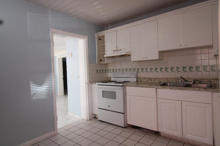 578 West 2nd Street Riviera Beach, FL 33404 - Photo 3 of 15 a kitchen with white cabinets and white appliances