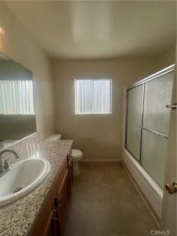 a bathroom with a granite countertop sink mirror vanity and a bathtub