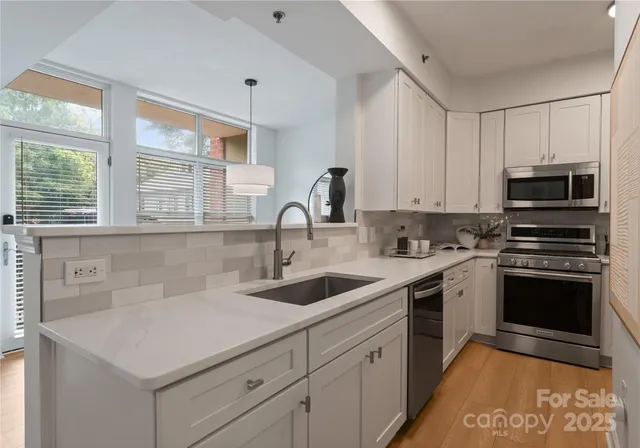 a kitchen with sink a microwave and cabinets