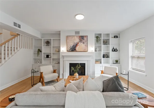 a living room with furniture a fireplace and a window