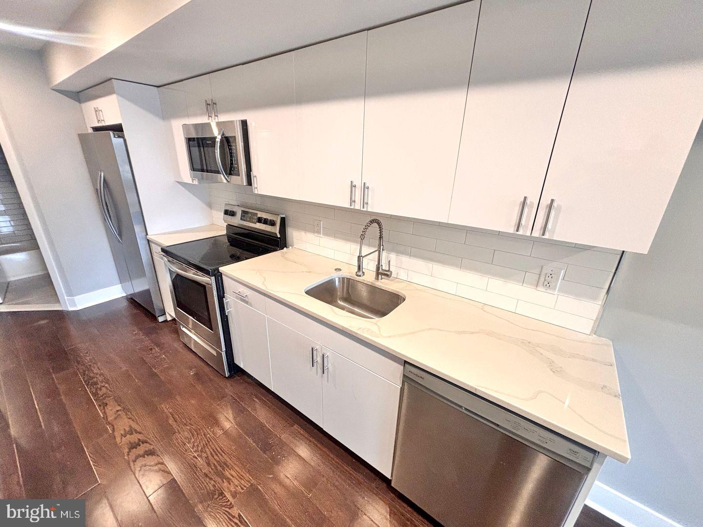 3255 Ridge Avenue Philadelphia, PA 19132 - Photo 3 of 28 a kitchen with a sink a stove and a refrigerator