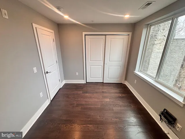 a view of a hallway with wooden floor and stairs