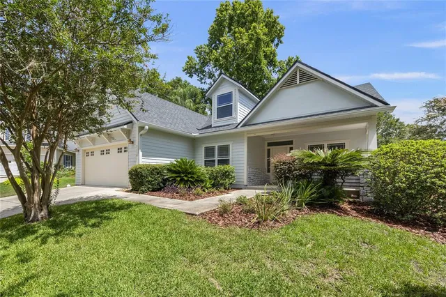 a view of a house with potted plants and a table and chairs