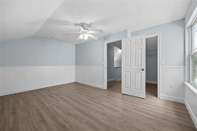 a view of backyard with wooden fence and trees