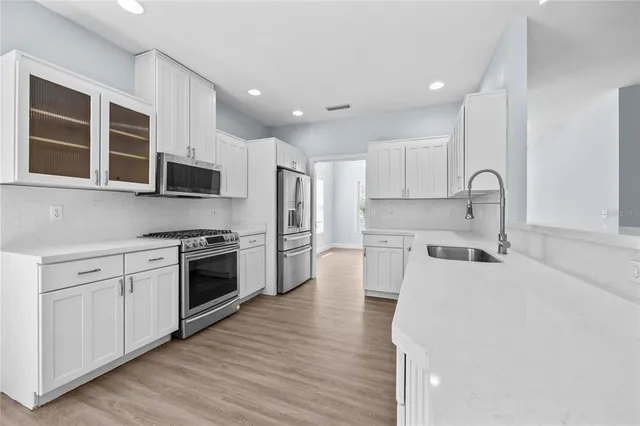 a kitchen with a sink a stove and cabinets