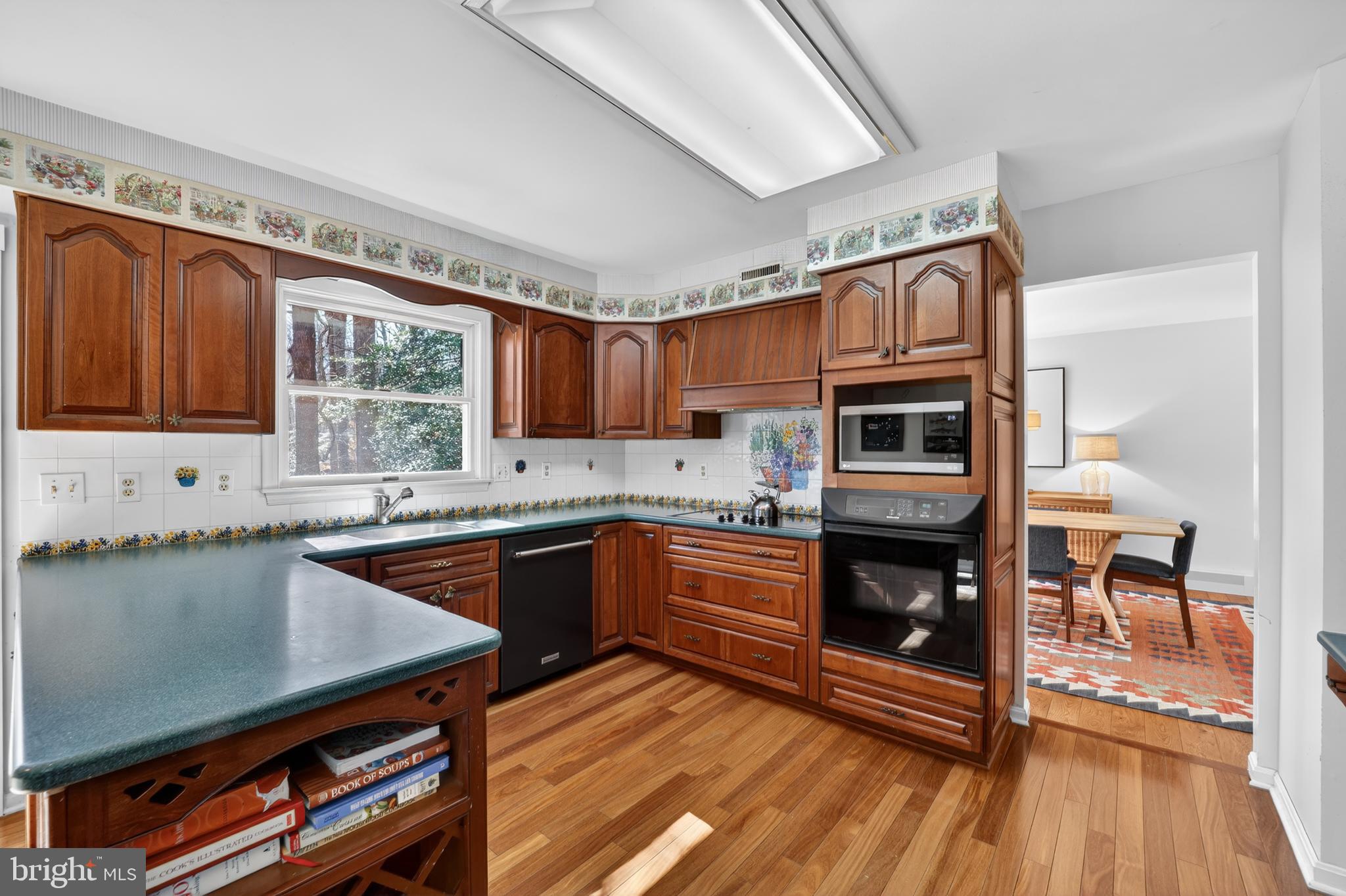655 Santa Maria Lane Davidsonville, MD 21035 - Photo 9 of 54 a kitchen with stainless steel appliances granite countertop a stove top oven a sink dishwasher a dining table and chairs with wooden floor