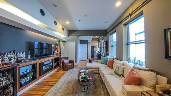 a living room with furniture and a book shelf