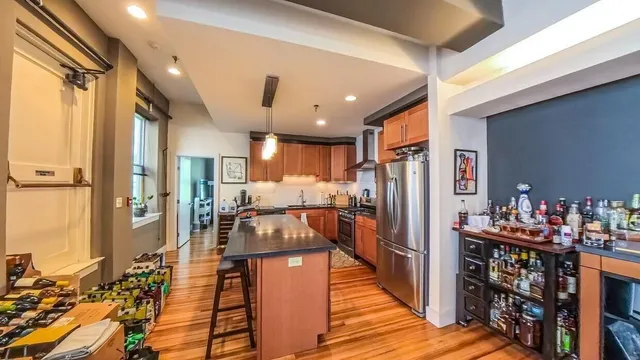 a kitchen with stainless steel appliances a refrigerator and wooden floor