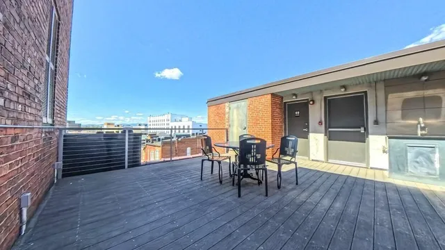 a view of a patio with table and chairs with wooden floor and fence