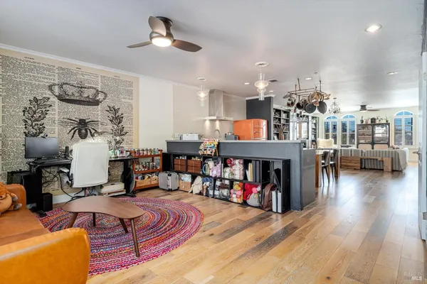 a kitchen with stainless steel appliances kitchen island granite countertop a table chairs in it and wooden floors