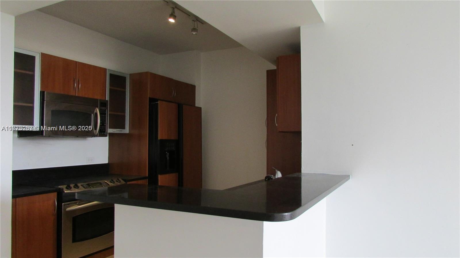 2775 Northeast 187th Street, Unit 205 Aventura, FL 33180 - Photo 20 of 53 a kitchen with a refrigerator and a stove top oven