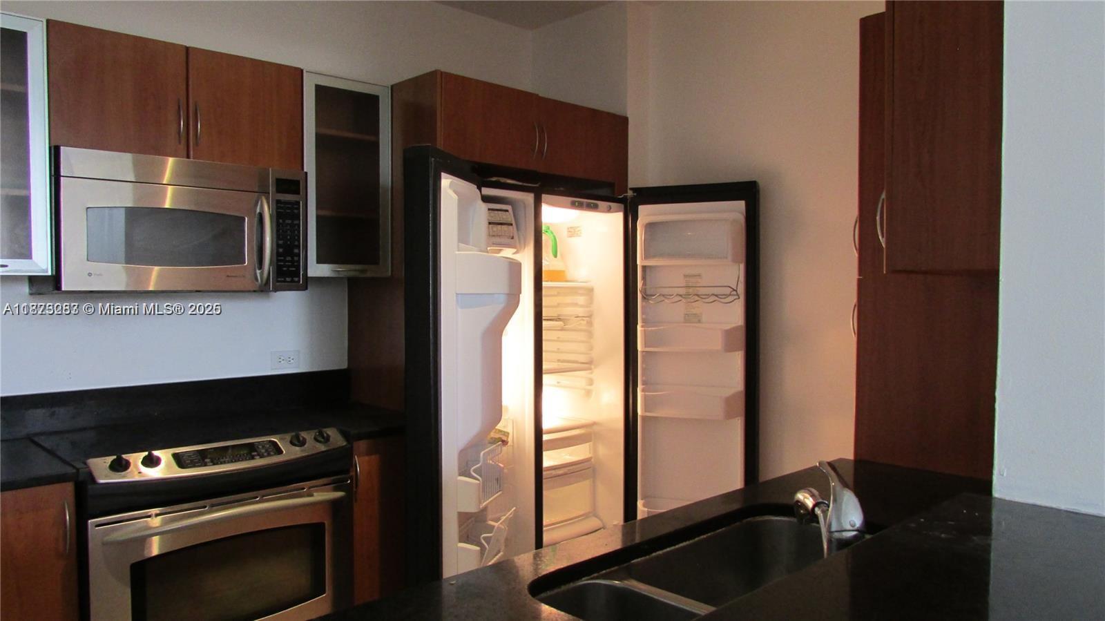 2775 Northeast 187th Street, Unit 205 Aventura, FL 33180 - Photo 21 of 53 a kitchen with a refrigerator and a stove top oven
