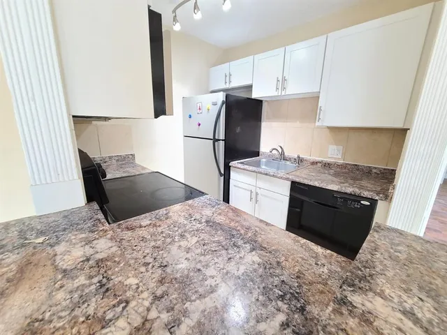 a kitchen with stainless steel appliances kitchen island granite countertop a sink stove and refrigerator