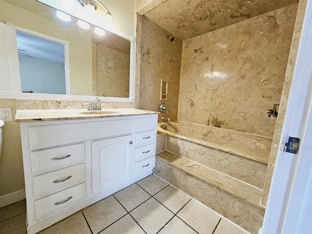 a bathroom with a granite countertop sink a toilet and a mirror