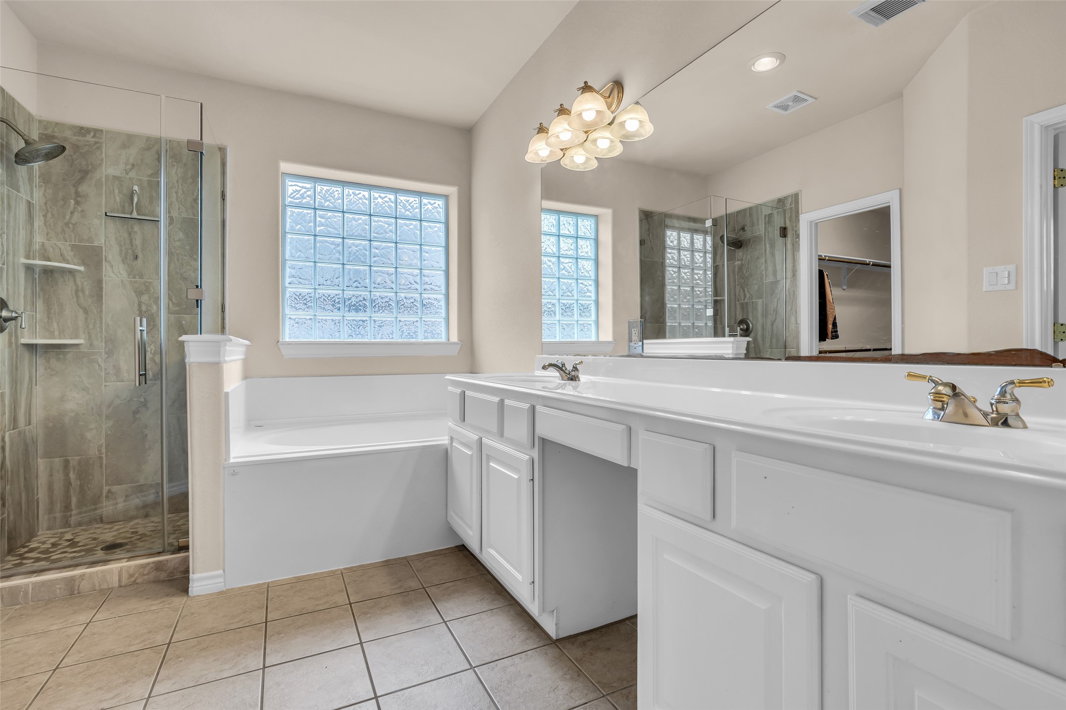 629 Spring Forest Drive Conroe, TX 77302 - Photo 9 of 39 Primary bathroom - two vanities, bathtub, and frameless shower!