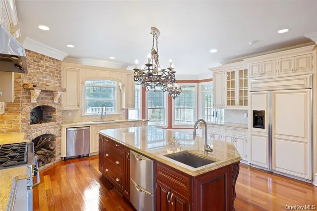 a large kitchen with stainless steel appliances granite countertop a lot of counter space and wooden floors