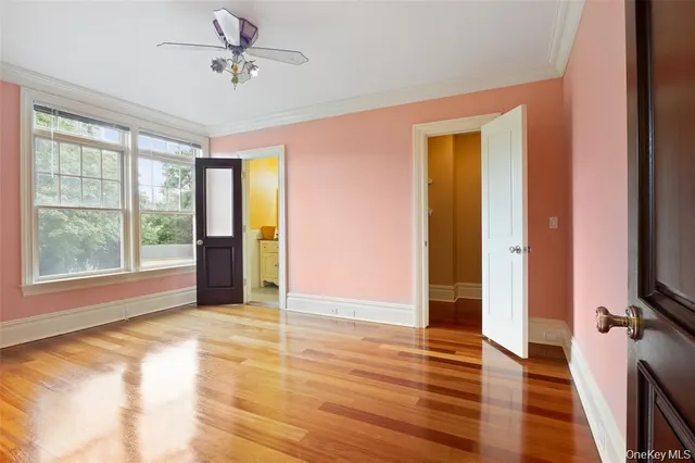 a view of an empty room with window wooden floor