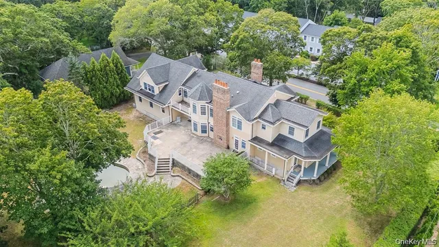 an aerial view of a house with a yard and trees all around