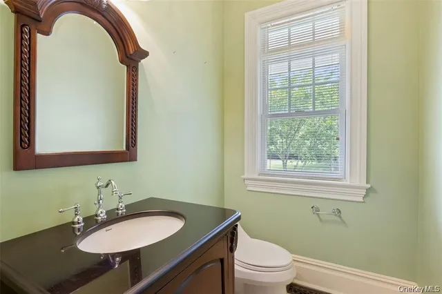 a bathroom with a sink a toilet and a mirror