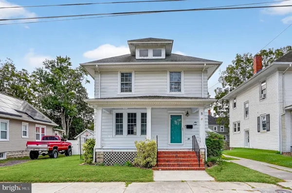 a front view of a house with a garden and plants