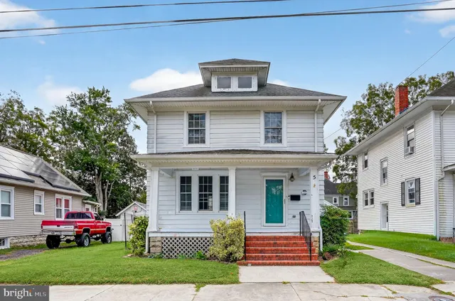 a front view of a house with a garden and plants