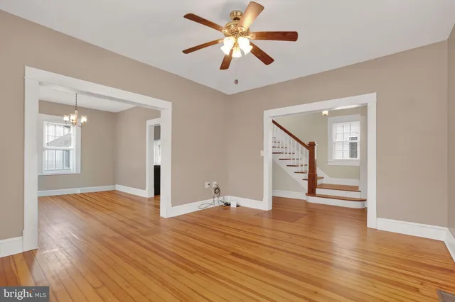 a view of an empty room with window and wooden floor