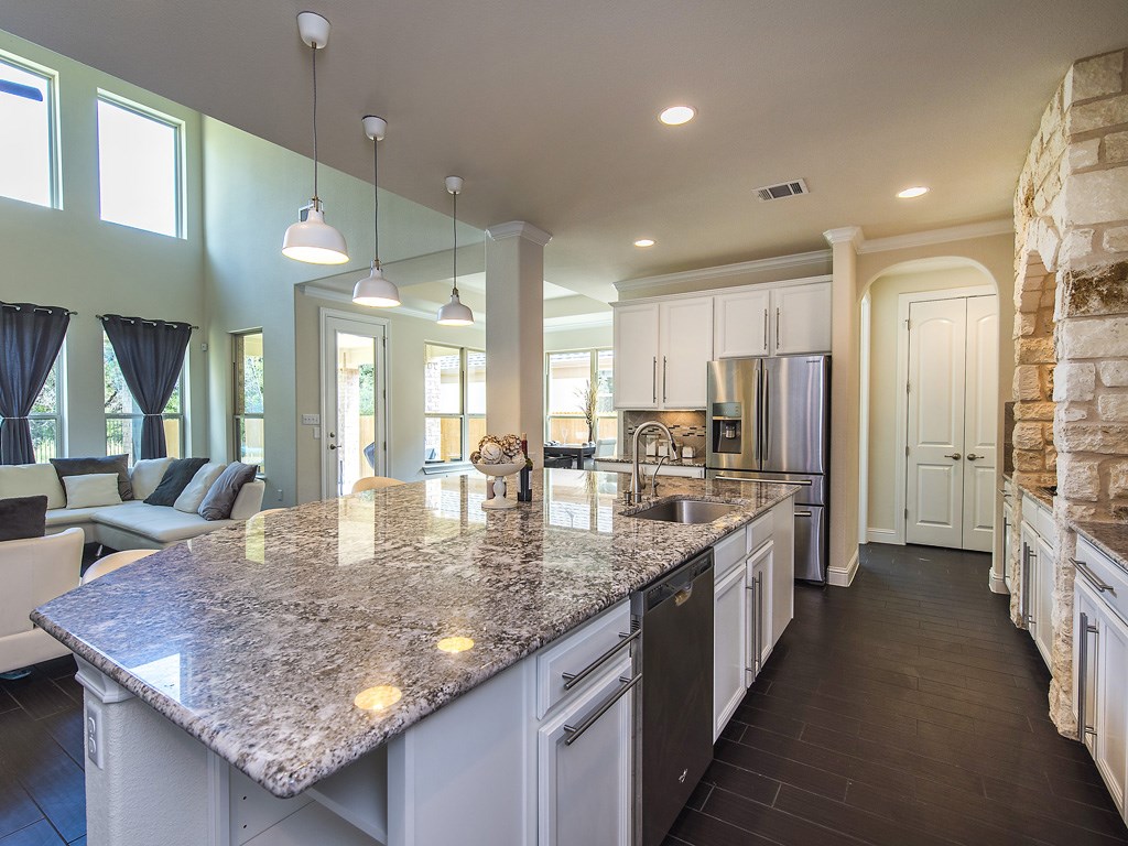 a kitchen with stainless steel appliances granite countertop a kitchen island sink refrigerator and cabinets