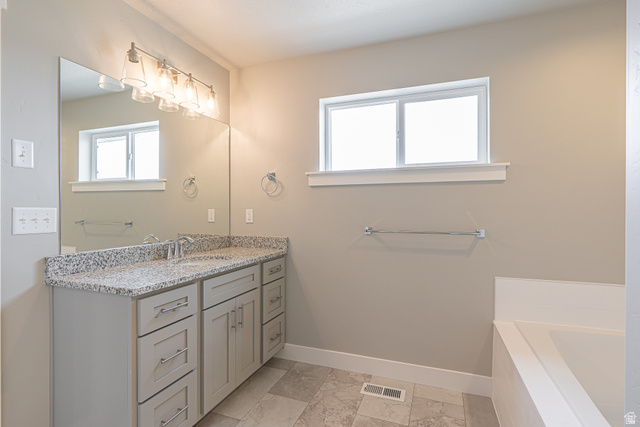 2257 South 1090 West, Unit 74 Nibley, UT 84321 - Photo 18 of 40 Bathroom featuring a double vanity with light-colored cabinetry, a speckled countertop, and dual undermount sinks