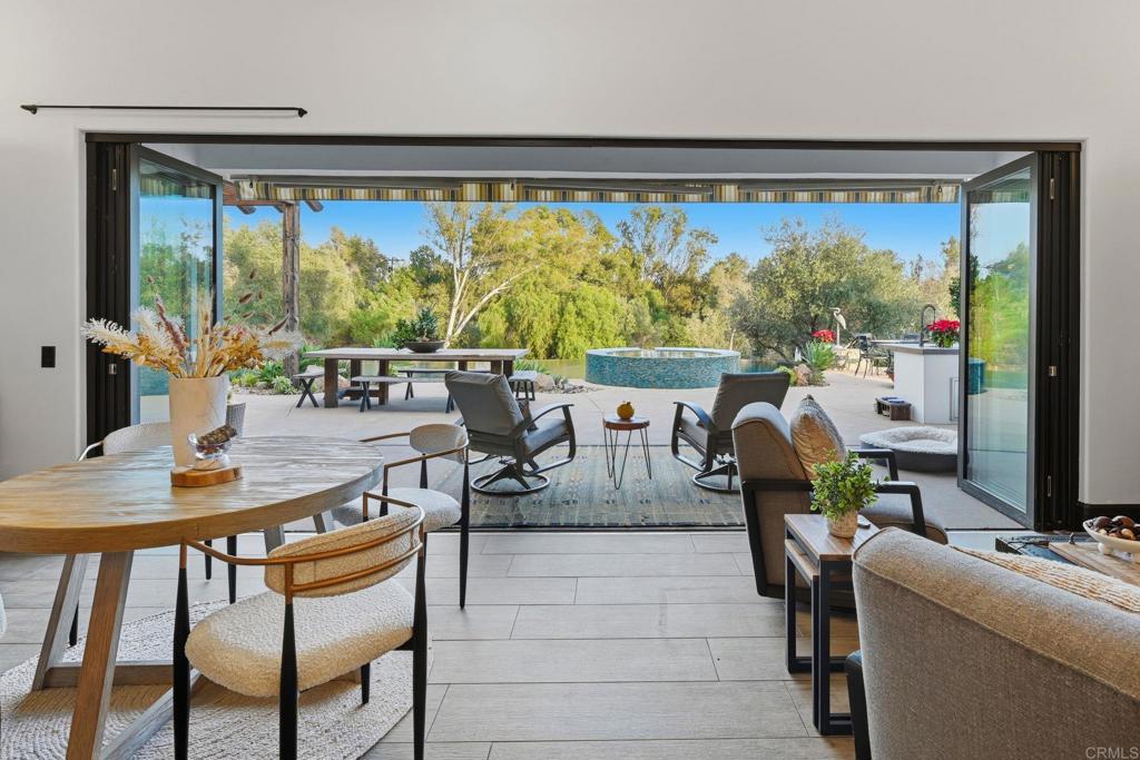 1111 Palomino Road Fallbrook, CA 92028 - Photo 13 of 64 a living room with large glass windows table and chairs