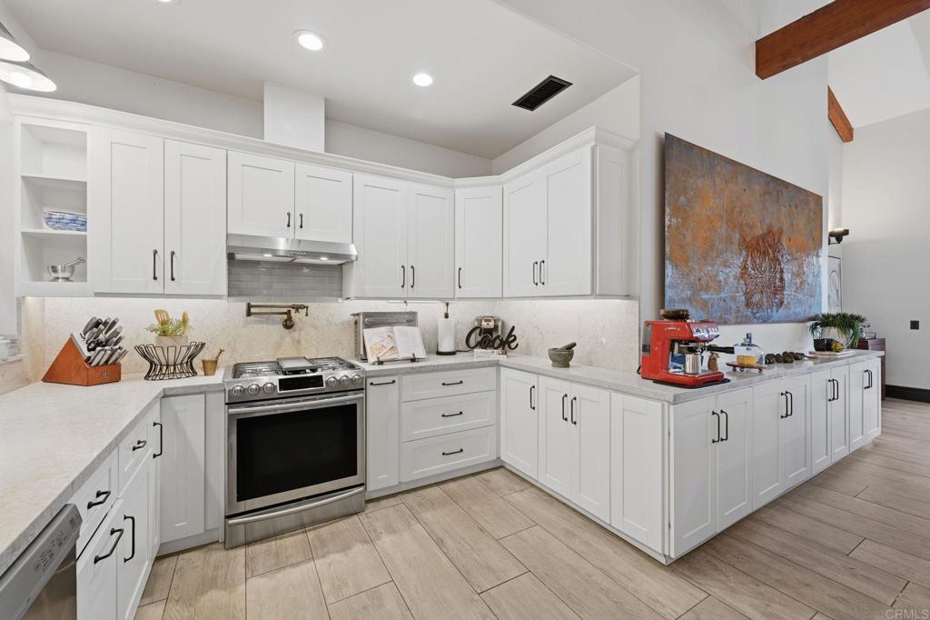 1111 Palomino Road Fallbrook, CA 92028 - Photo 17 of 64 a kitchen with granite countertop white cabinets and white appliances
