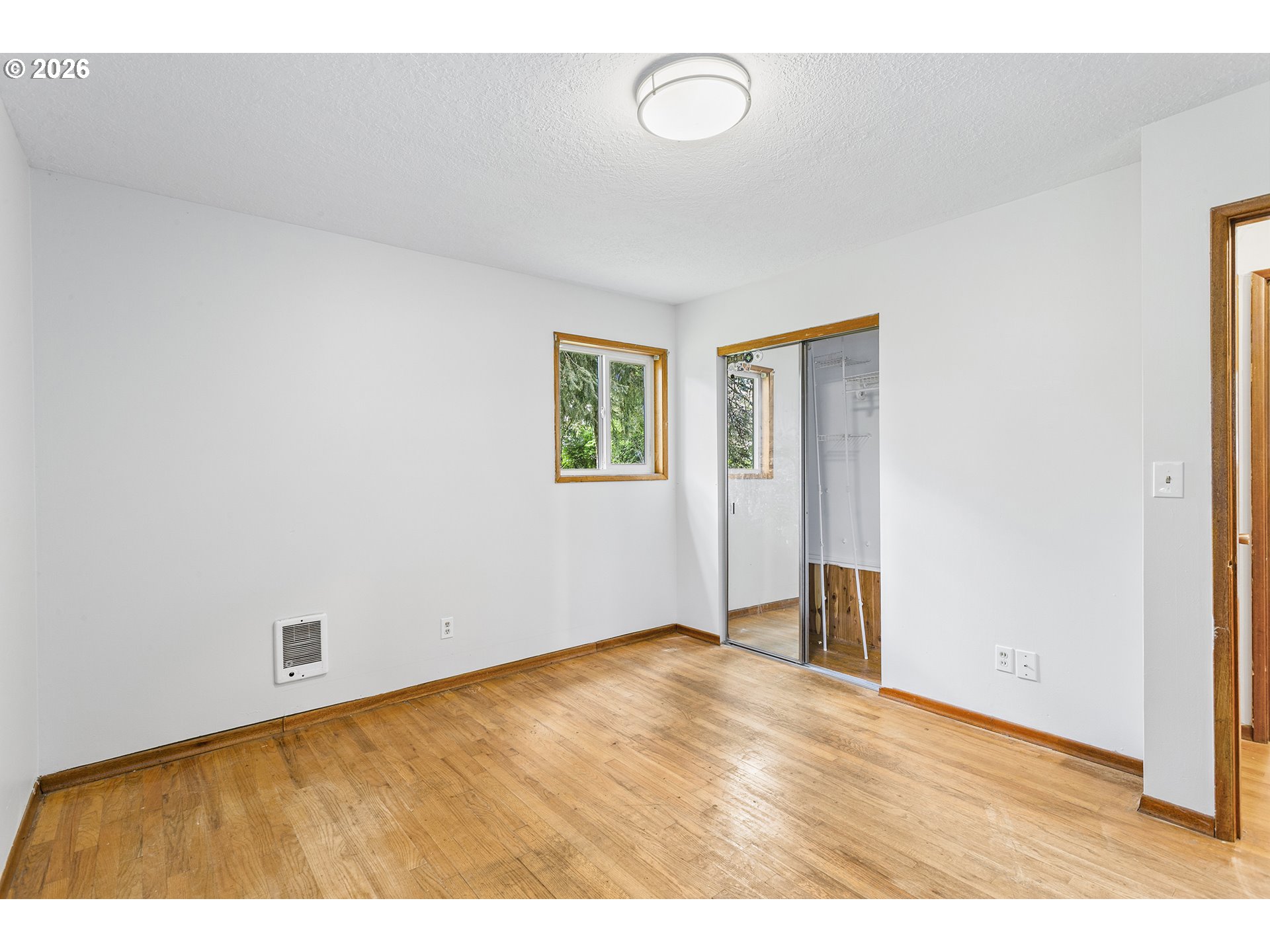 9375 Southwest Killarney Lane Tualatin, OR 97062 - Photo 12 of 25 a view of an empty room with wooden floor and a window