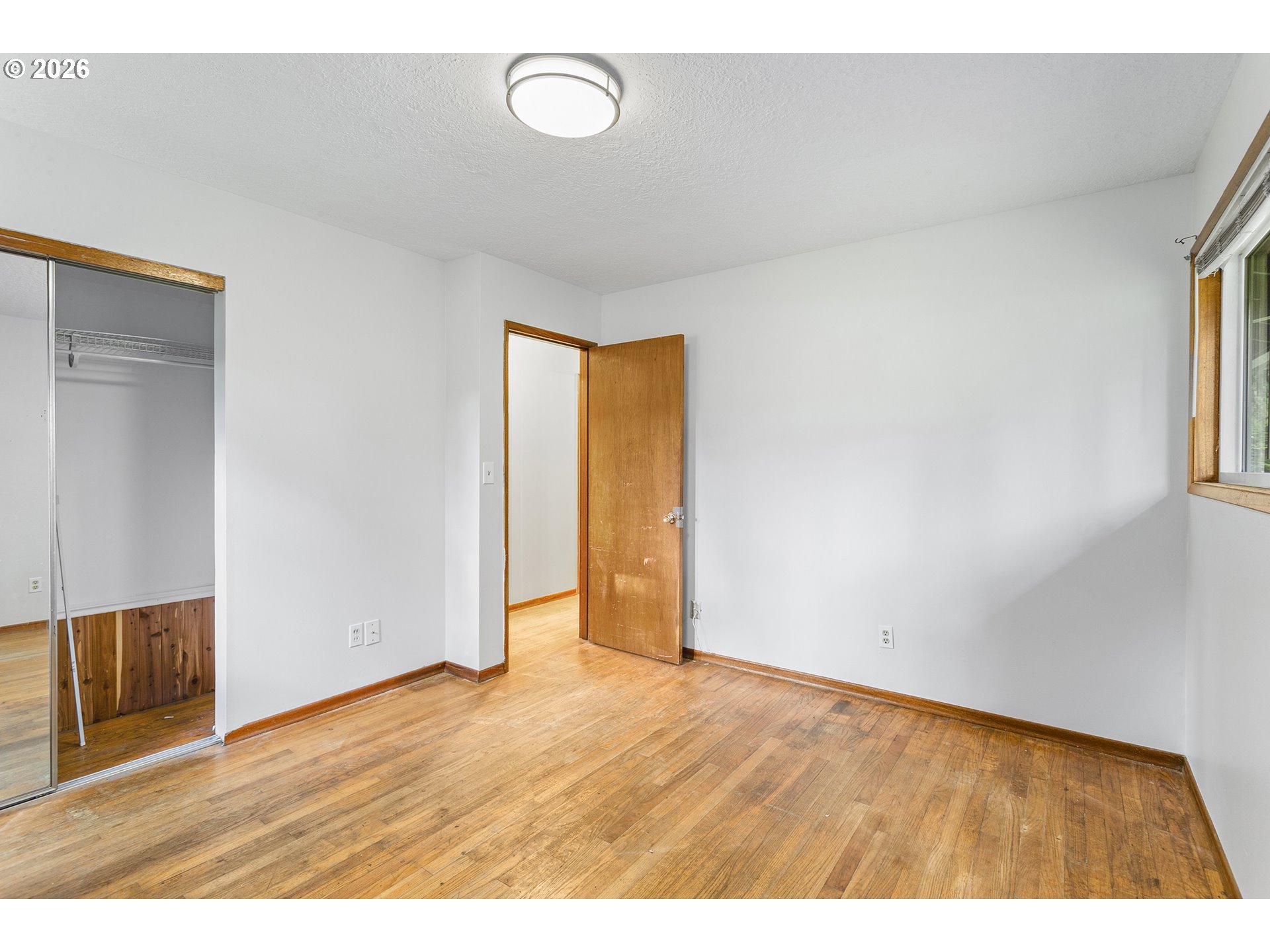 9375 Southwest Killarney Lane Tualatin, OR 97062 - Photo 13 of 25 a view of an empty room with wooden floor and a window