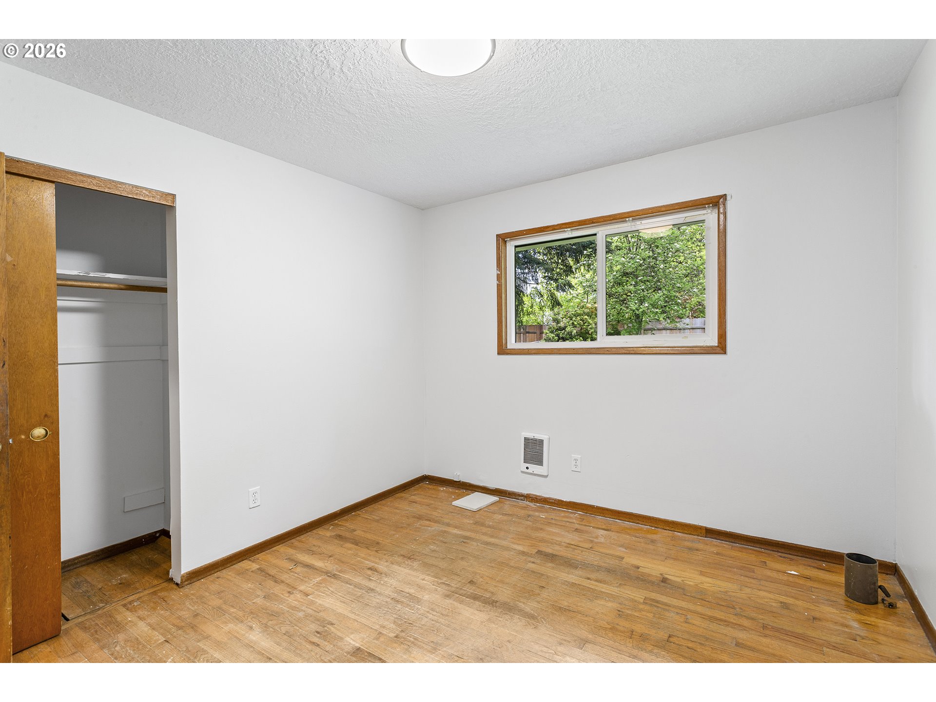 9375 Southwest Killarney Lane Tualatin, OR 97062 - Photo 18 of 25 a view of an empty room with wooden floor and a window