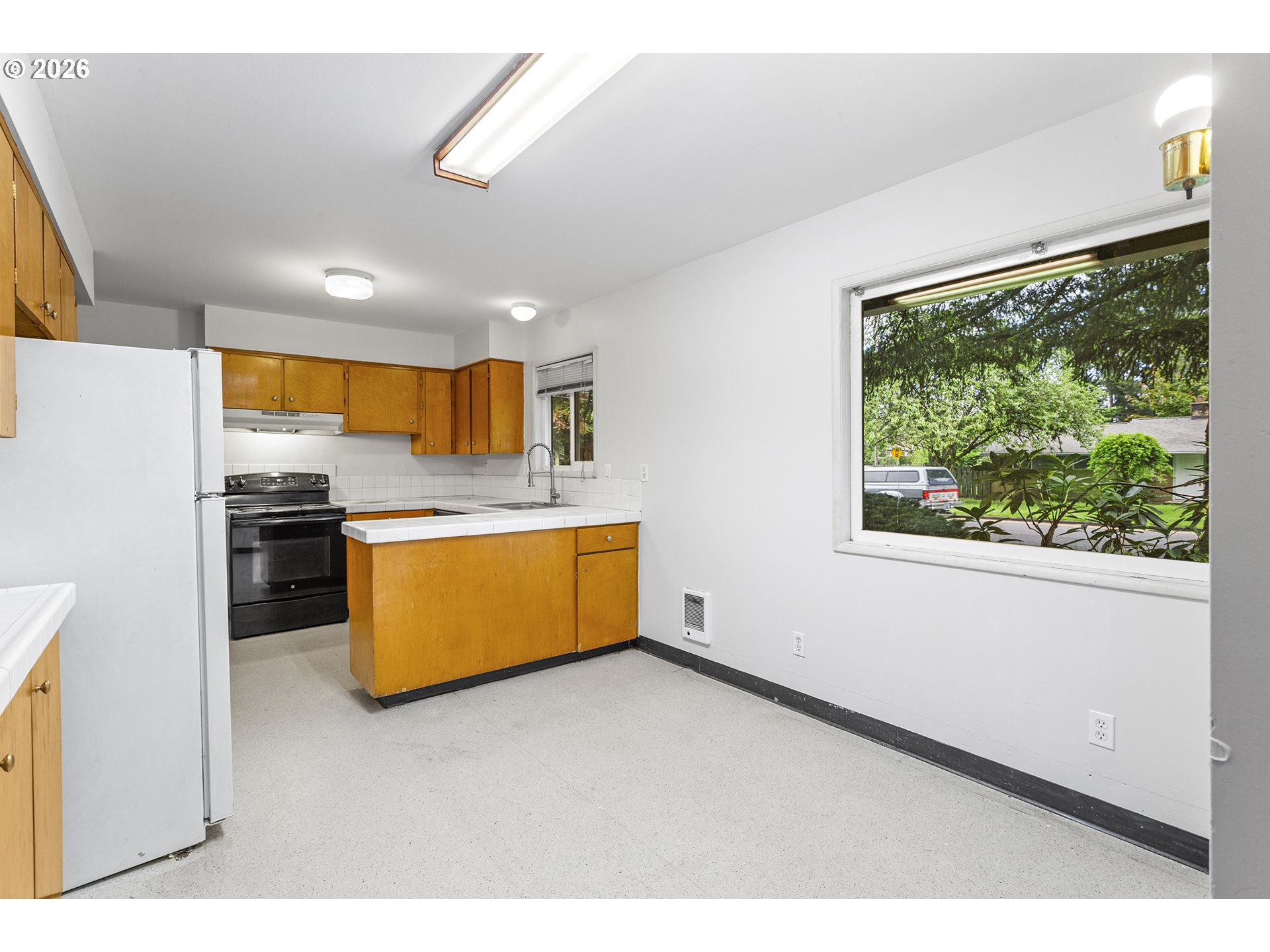 9375 Southwest Killarney Lane Tualatin, OR 97062 - Photo 5 of 25 a large white kitchen with a large window
