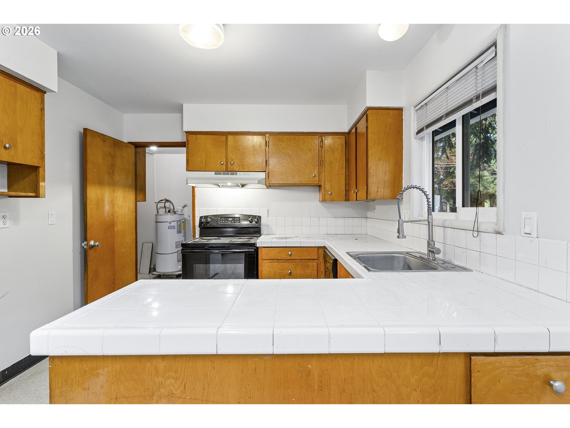 9375 Southwest Killarney Lane Tualatin, OR 97062 - Photo 8 of 25 a kitchen with a sink cabinets and a wooden floor
