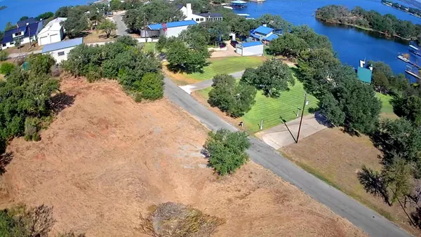 an aerial view of a house with a yard and trees all around