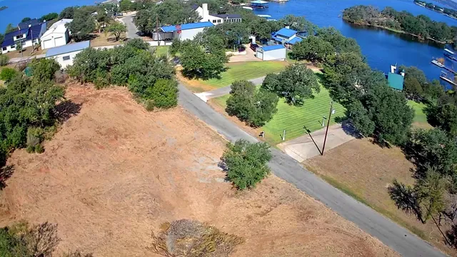 an aerial view of a house with a yard and trees all around
