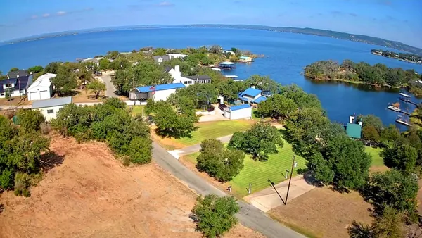 a view of a garden with lawn chairs under an umbrella
