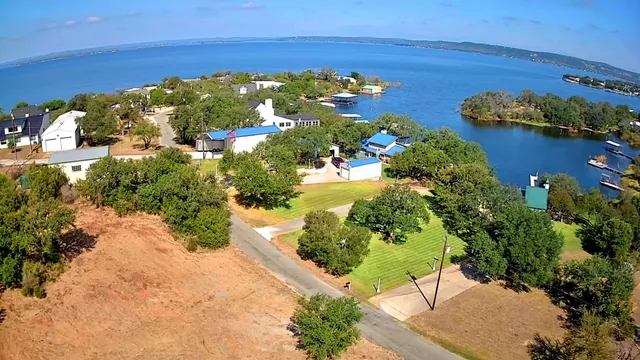 a view of a garden with lawn chairs under an umbrella