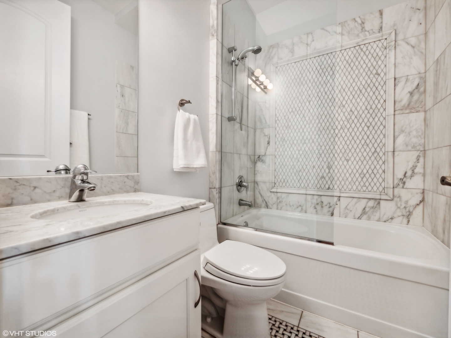 1428 West Irving Park Road, Unit 3 Chicago, IL 60613 - Photo 14 of 18 a bathroom with a granite countertop sink toilet mirror and bathtub