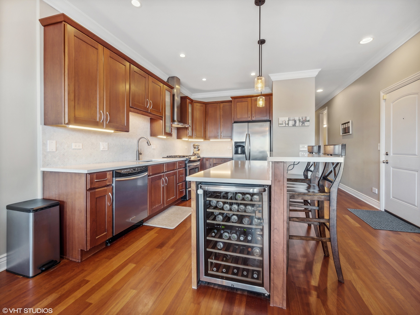 1428 West Irving Park Road, Unit 3 Chicago, IL 60613 - Photo 6 of 18 a kitchen with stainless steel appliances kitchen island granite countertop a sink a stove a dining table and chairs